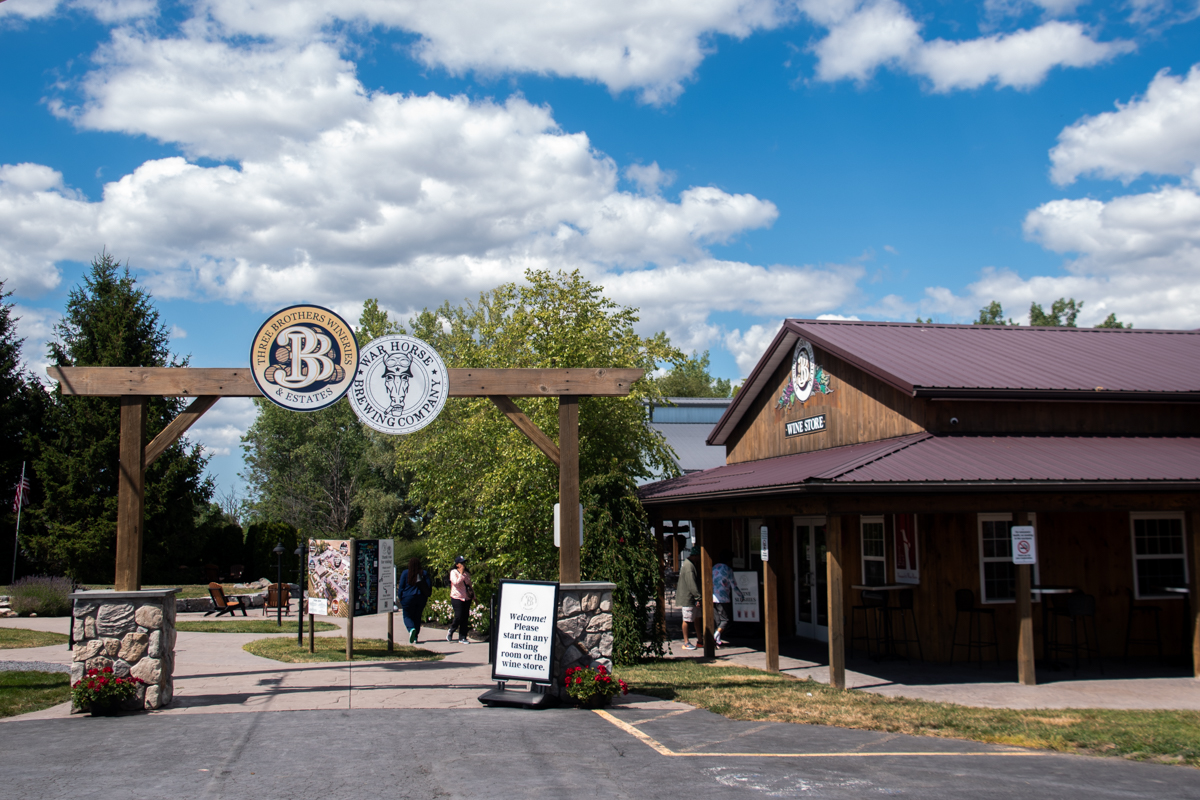 Entrance to Three Brothers Wineries & Estates and War Horse Brewing Company on the Seneca Lake Wine Trail, featuring a rustic wooden archway and wine store.