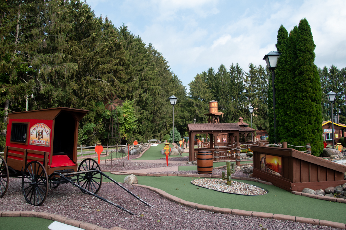 Western-themed mini golf at Charcoal Corral in Perry, NY – Outdoor miniature golf course with wagon props, windmills, and rustic décor, offering family-friendly fun near Letchworth State Park.