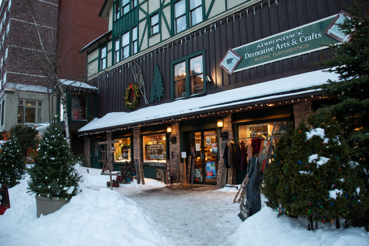 Snow-covered storefronts and cozy shops in downtown Lake Placid during winter