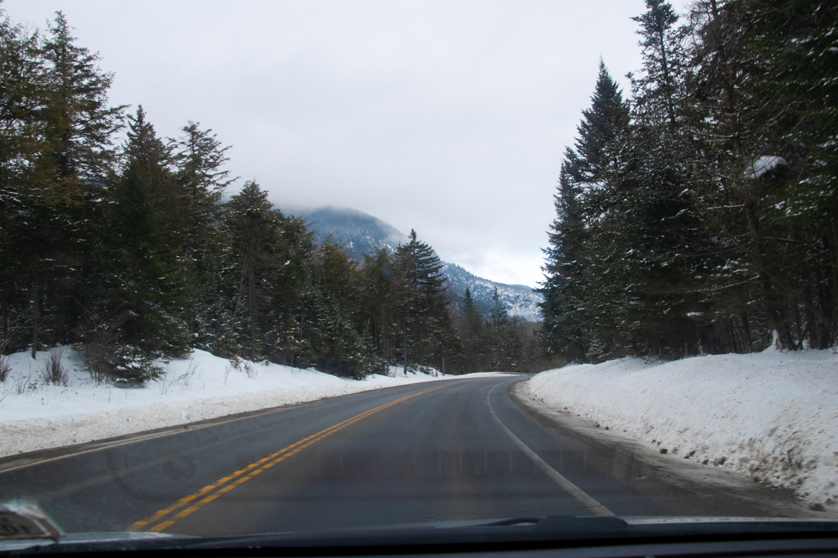 Scenic winter drive through the Adirondack Mountains near Lake Placid with snow-lined road and trees