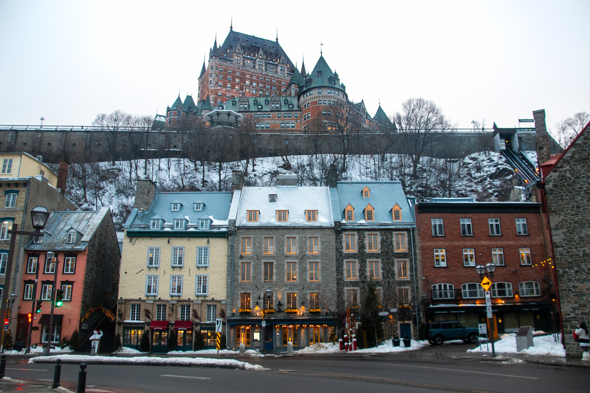 Château Frontenac overlooking Lower Town in Old Quebec City with snow-covered rooftops in winter.