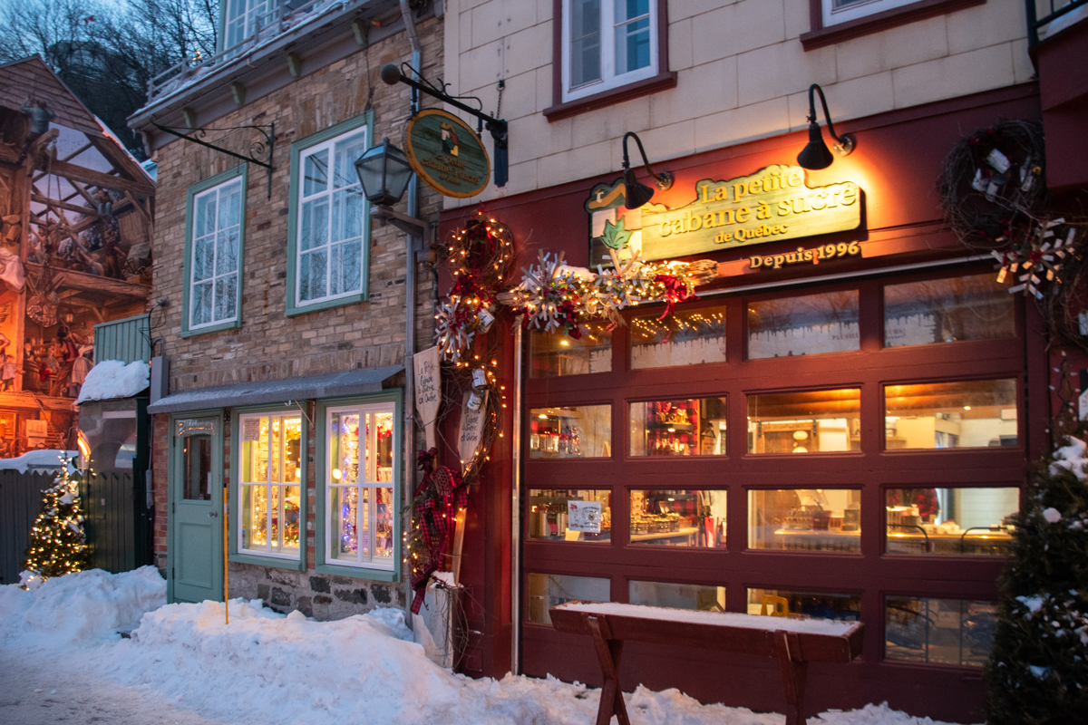 La Petite Cabane à Sucre maple shop in Petit-Champlain decorated with holiday lights and snow in Quebec City
