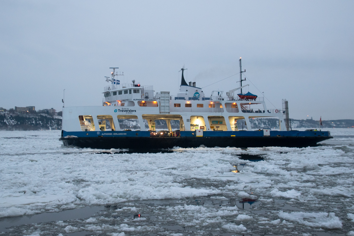 Ferry navigating ice floes on the St. Lawrence River in Quebec City during winter