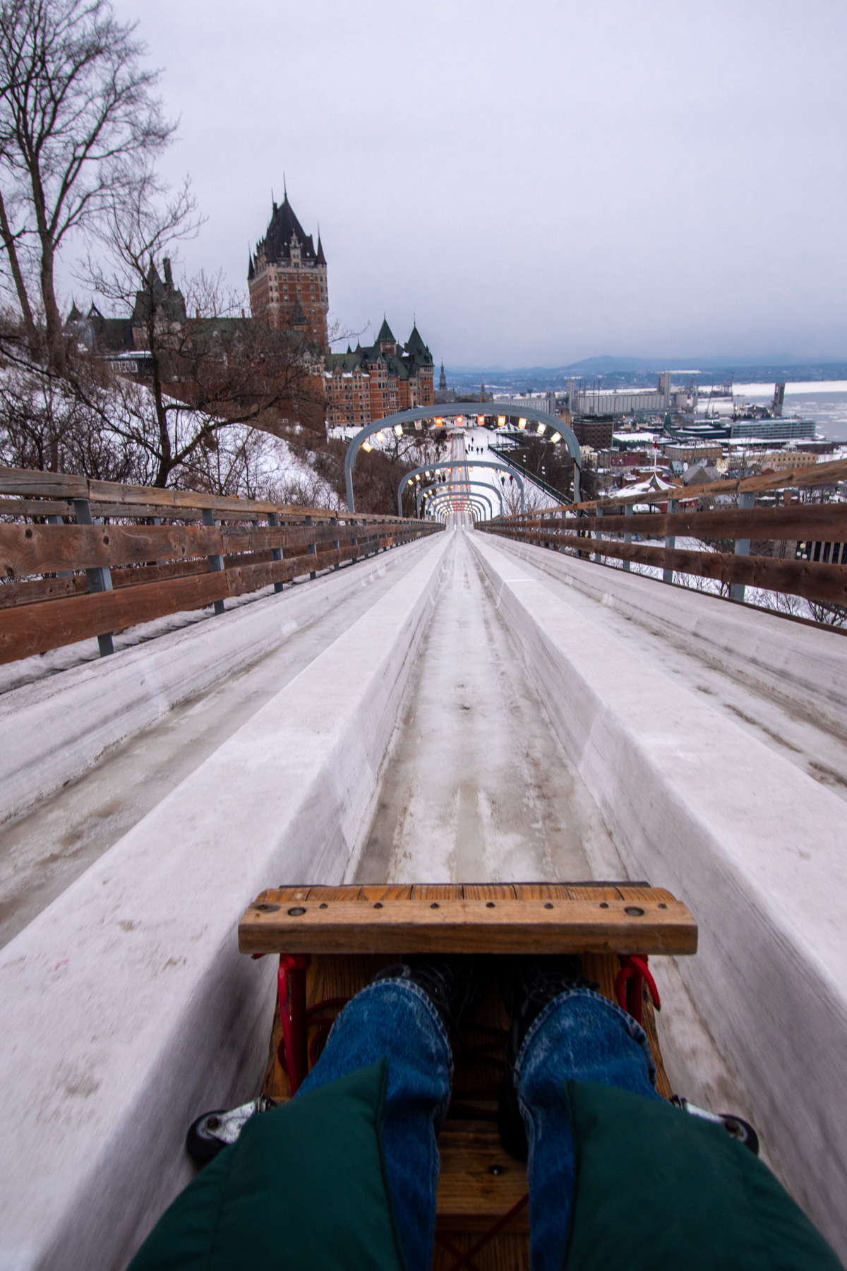 Point-of-view view down the Dufferin Terrace Toboggan Slide with Château Frontenac and Quebec City visible ahead.