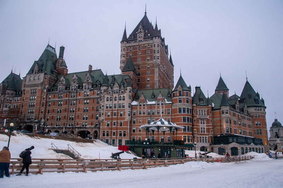 Wide view of the Dufferin Terrace toboggan slide and Château Frontenac during a winter afternoon in Quebec City