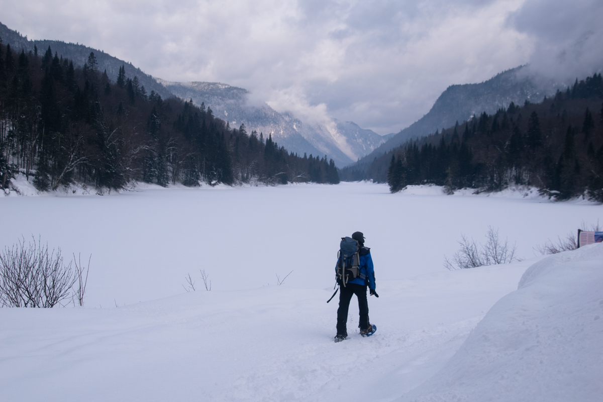 Hiker snowshoeing across a frozen valley in Jacques-Cartier National Park during winter
