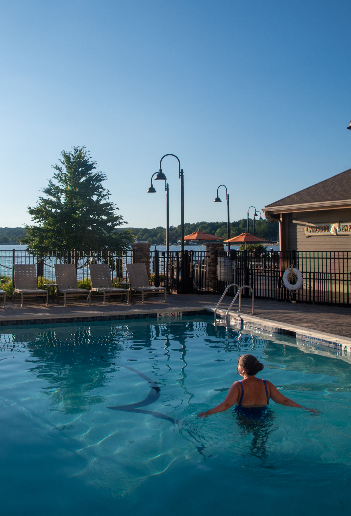 Guest relaxing in the outdoor pool at Chautauqua Harbor Hotel overlooking Chautauqua Lake in Celoron, New York.