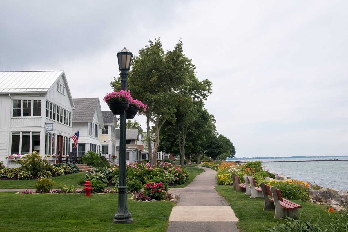 Landscaped waterfront walking path lined with flowers, benches, and historic homes in Lakeside Chautauqua, Ohio.