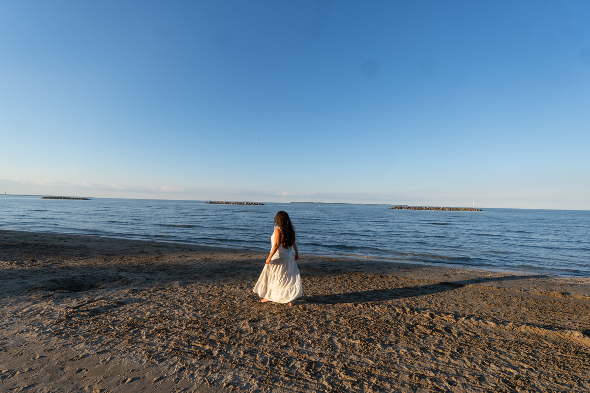 Woman walking along the beach at sunset at East Harbor State Park in Lake Erie Shores & Islands, Ohio.