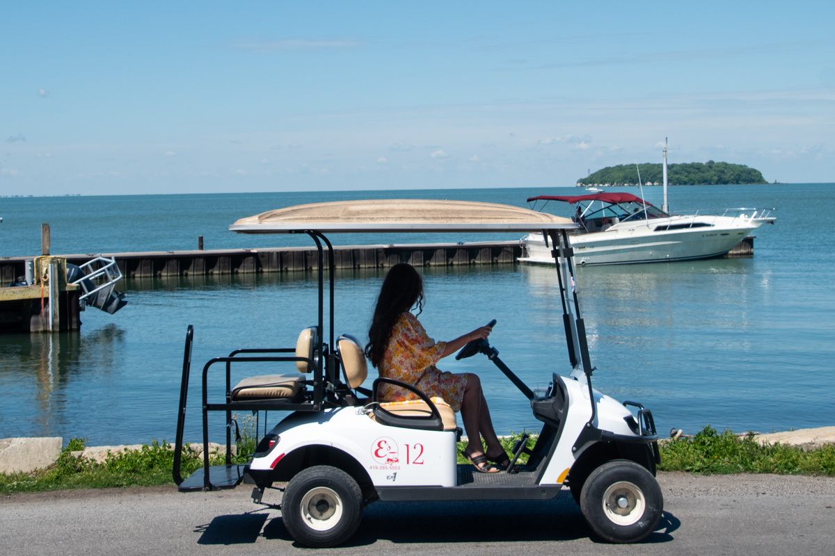 Woman driving a golf cart along the waterfront in Put-in-Bay on South Bass Island, Ohio.
