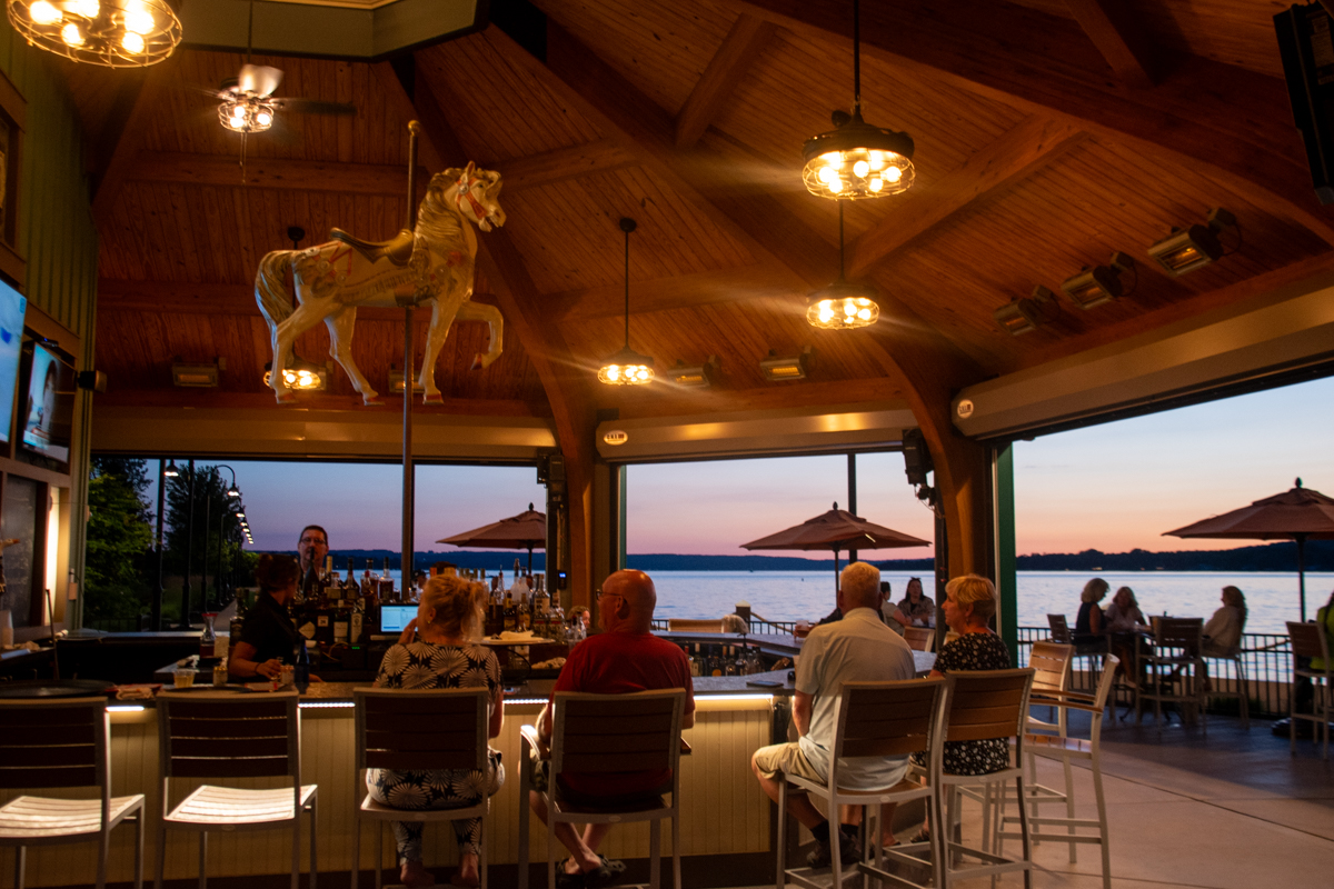 Guests enjoying drinks at the Carousel Bar overlooking Chautauqua Lake at Chautauqua Harbor Hotel.