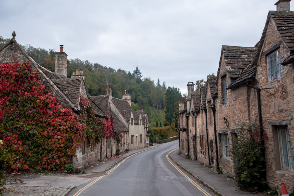 Historic stone cottages lining a winding road in Castle Combe, England.