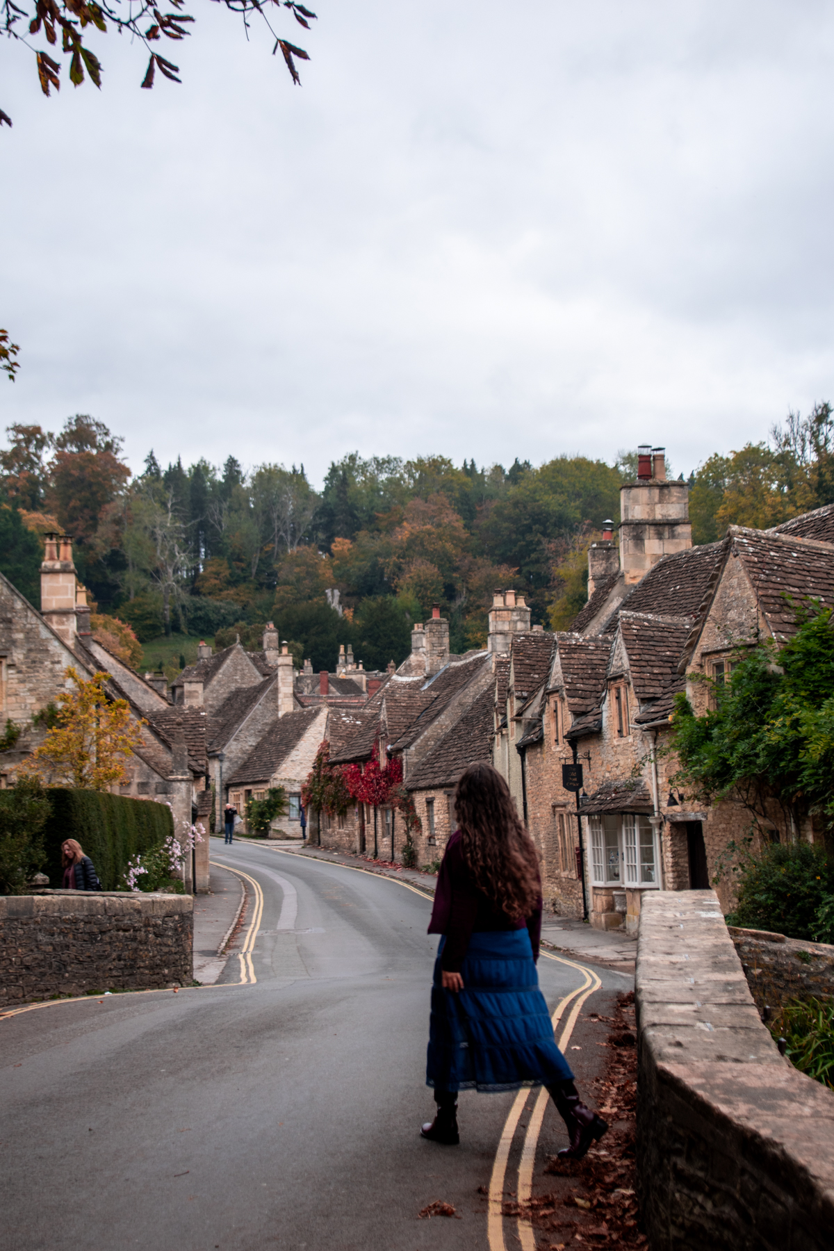 Woman walking on the Castle Combe Bridge.