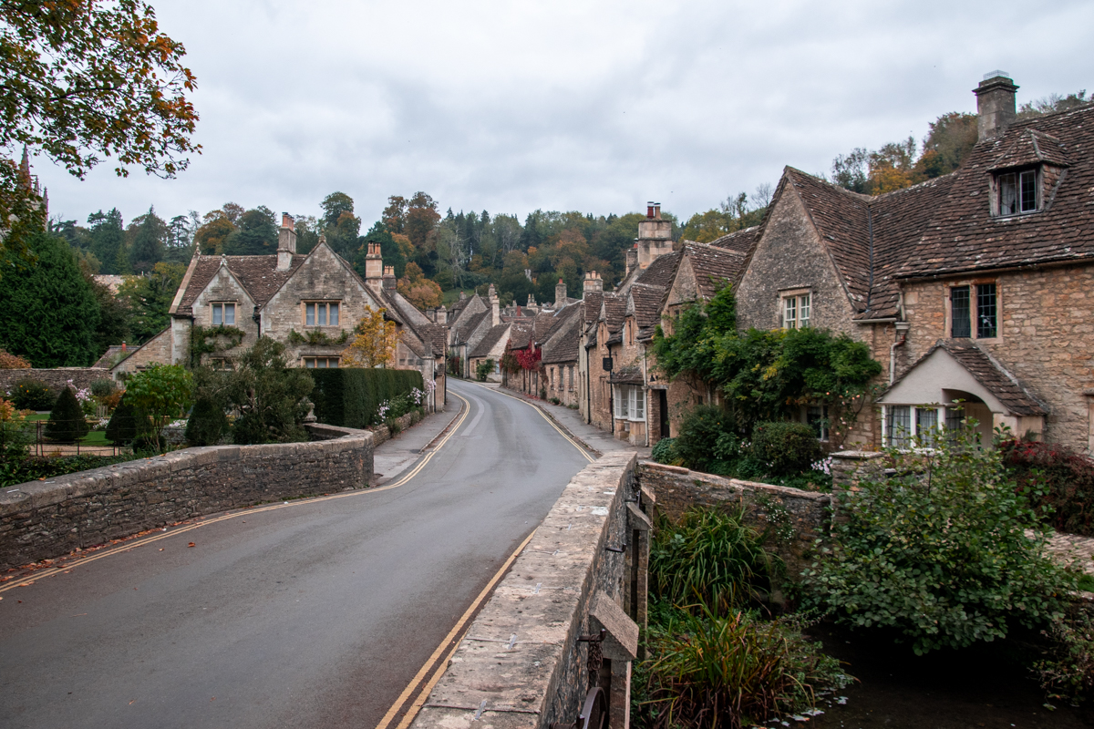 Stone bridge and historic cottages lining the main street in Castle Combe, England.