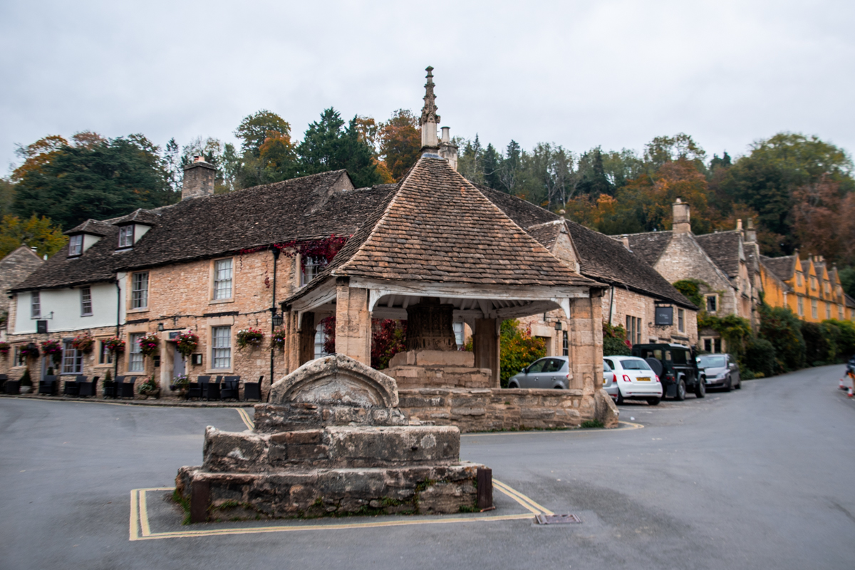 Historic Market Cross and stone cottages in Castle Combe, Cotswolds, England.